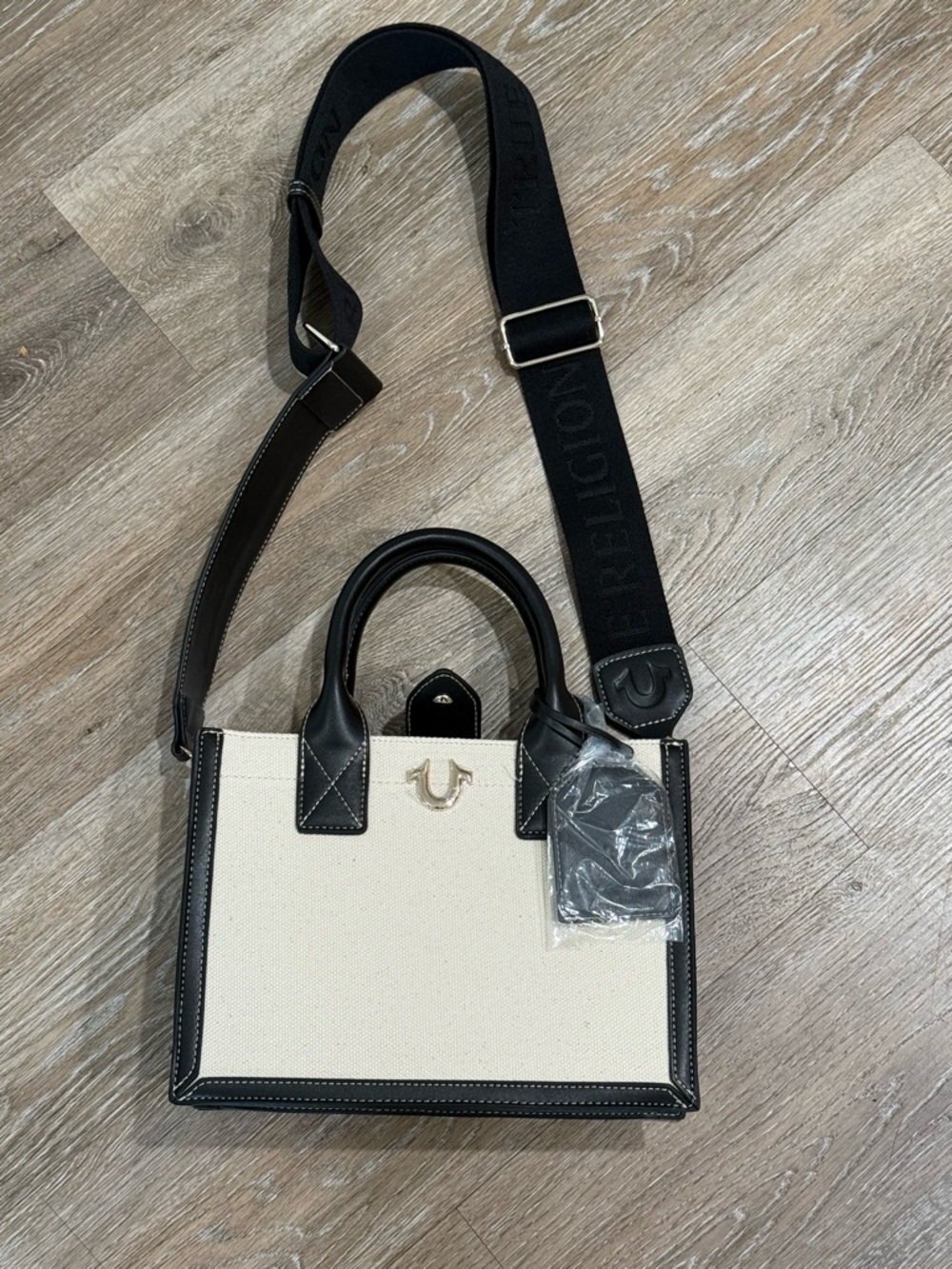 True Religion Cream Canvas Satchel with Black Trim and Adjustable Logo Strap